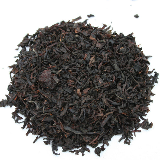 Lose Teeblätter in dunkler Farbe mit sichtbaren Kirschfruchtstücken, Schwarztee Wildkirsche von Grenzland-Genuss.