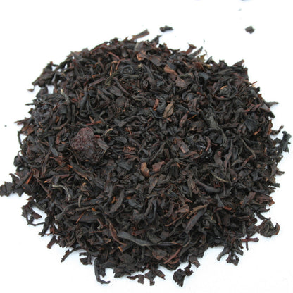 Lose Teeblätter in dunkler Farbe mit sichtbaren Kirschfruchtstücken, Schwarztee Wildkirsche von Grenzland-Genuss.