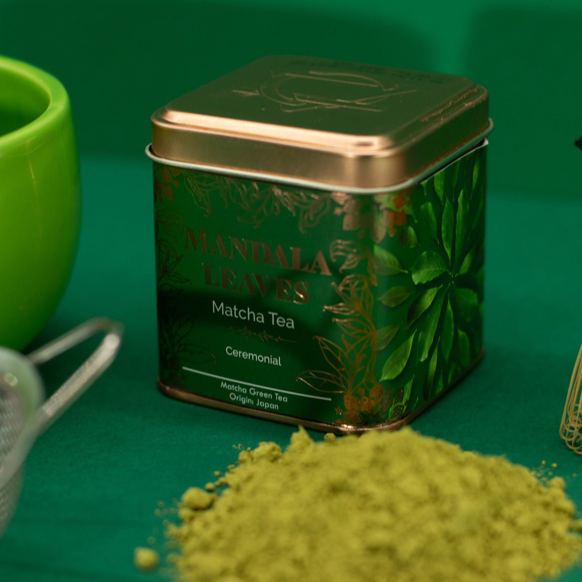 Zwei Dosen Bio-Matcha-Tee, eine für Zeremonial und eine für kulinarische Anwendungen, auf grünem Hintergrund.
